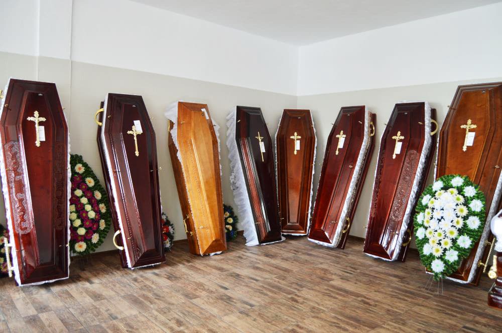 Sicrie din lemn masiv aliniate în sala de expunere