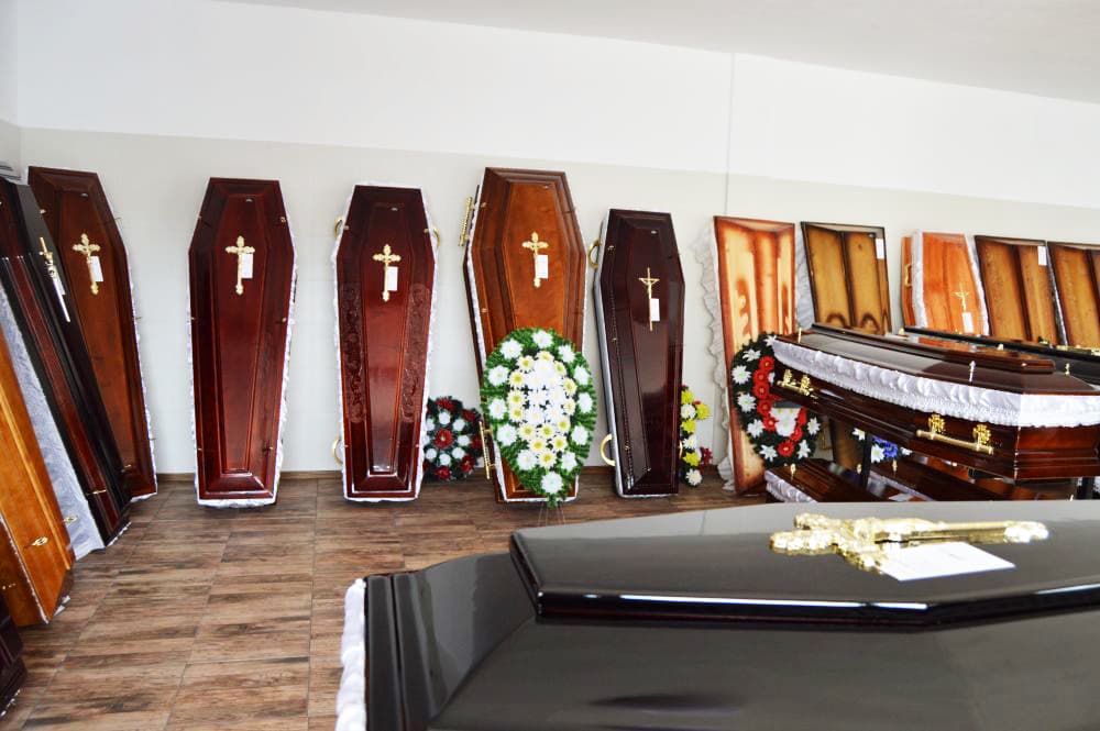 Sicrie din lemn aliniate în sala de expunere